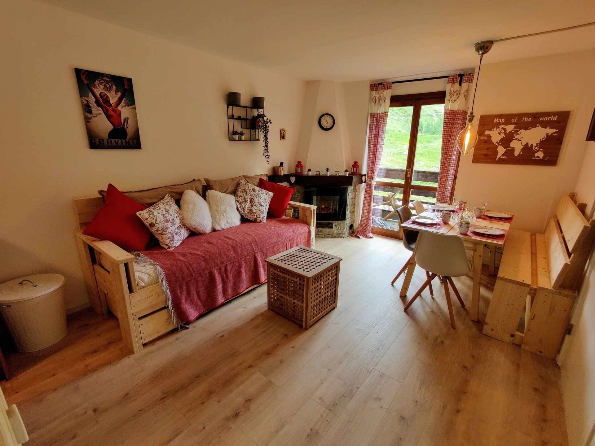 Overview of the living room with a sofa bed, set table, fireplace and mountain view