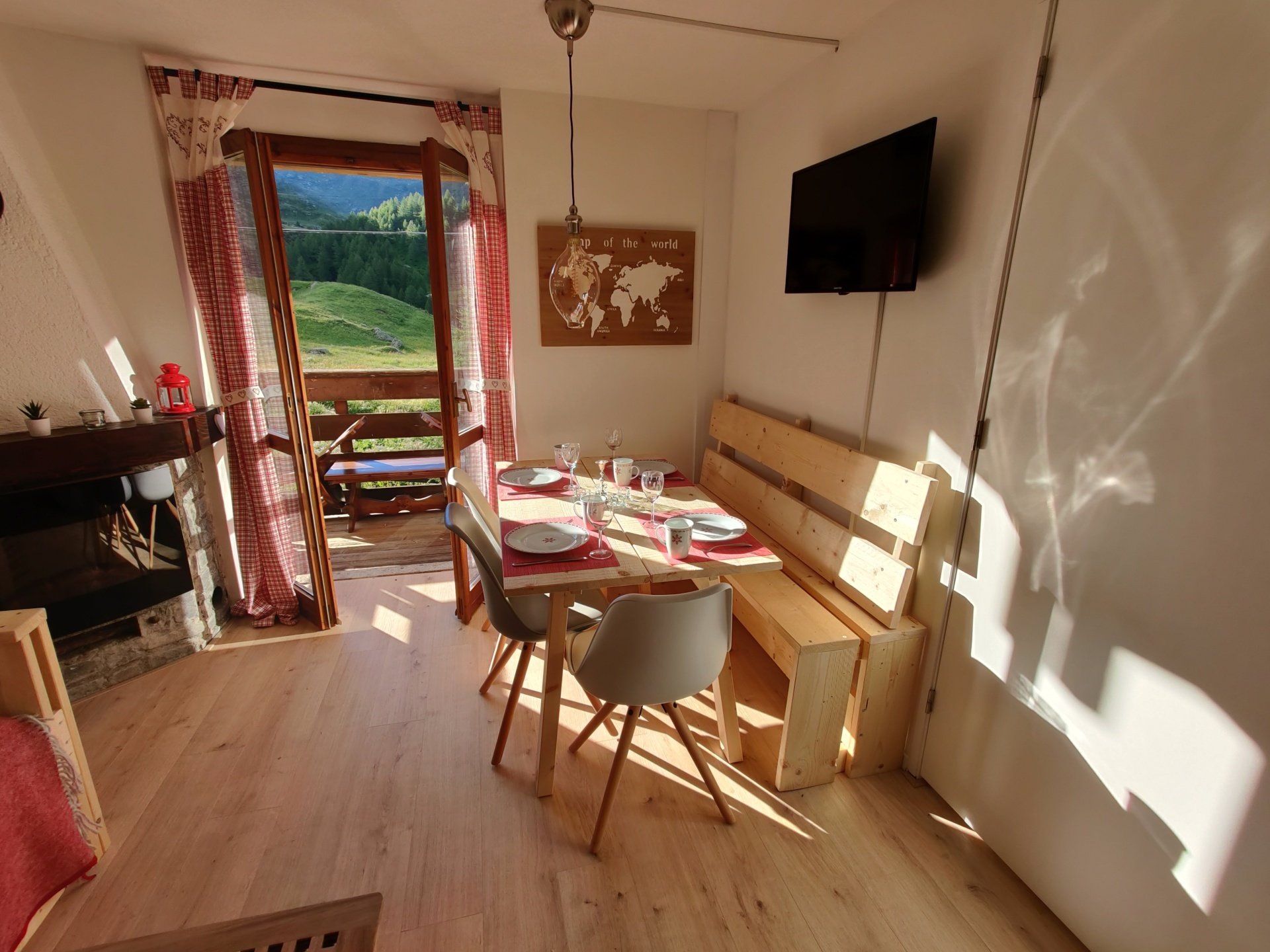Overview picture of the living room with a set table and open window.
