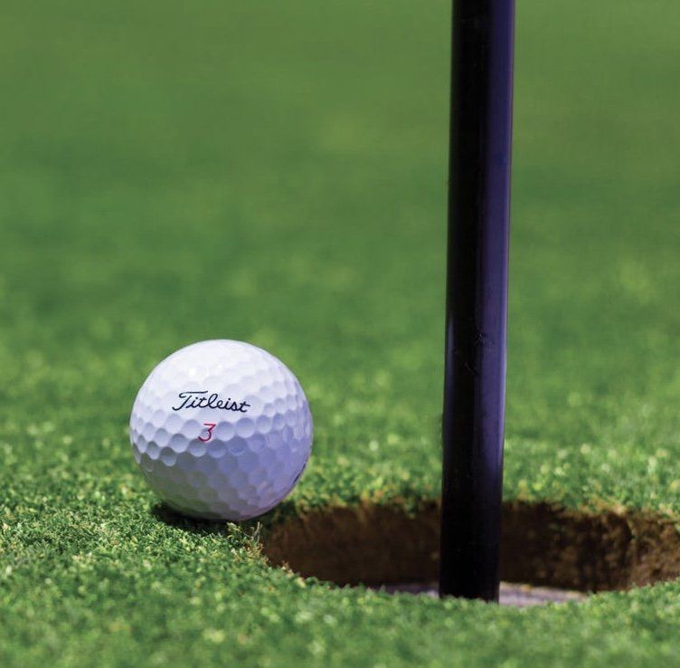 A golf ball next to the put