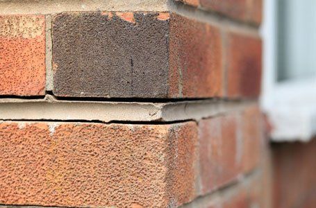 cracked and loose render of cavity wall