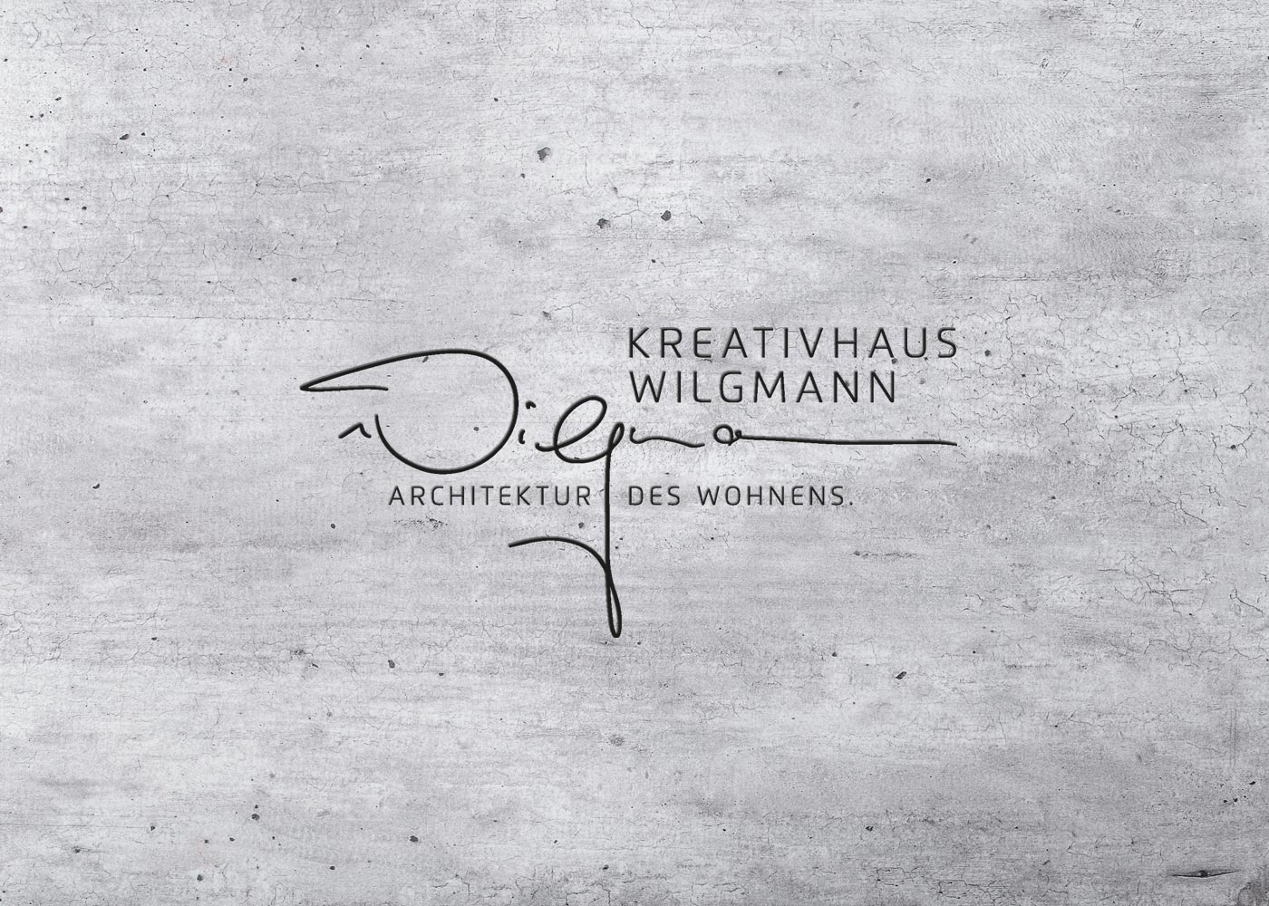 Ein Logo für Kreativhaus Wilgmann befindet sich auf einer Betonfläche