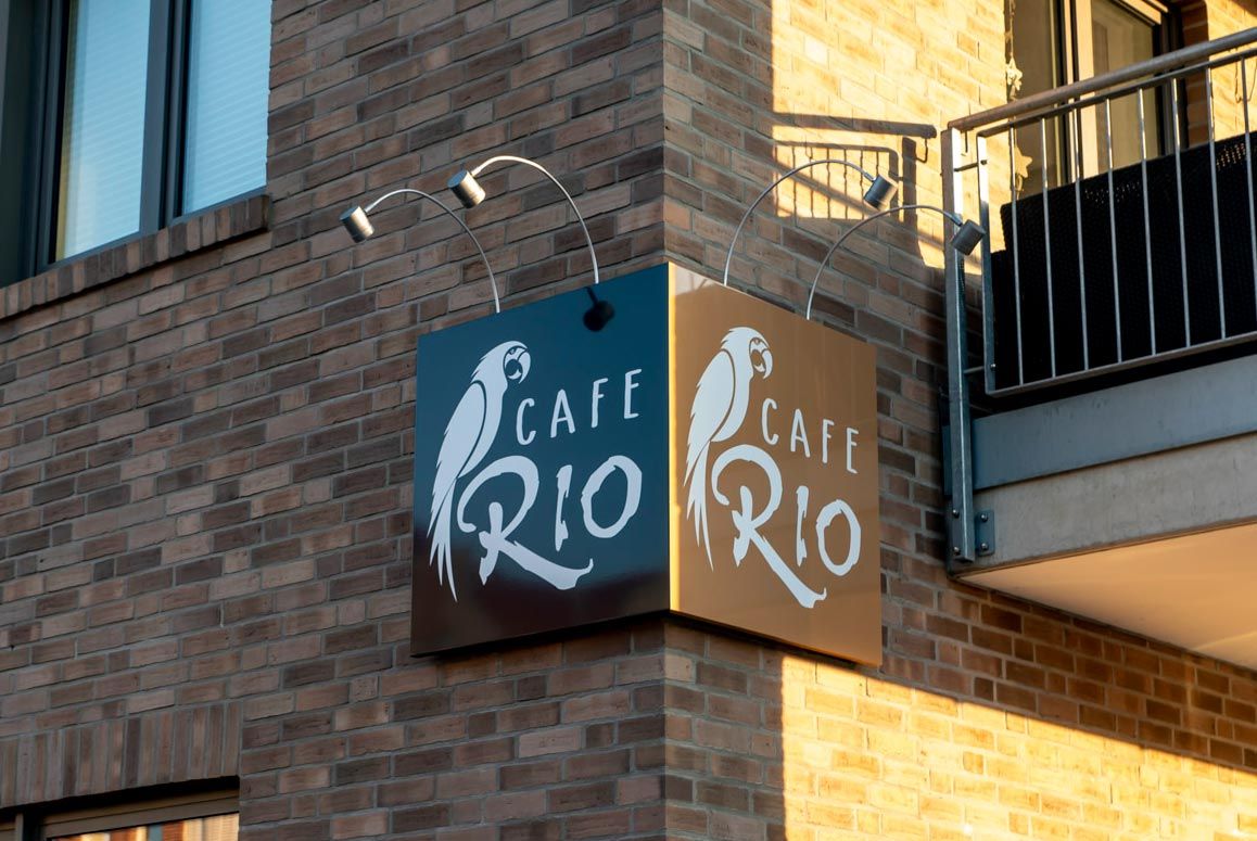 Ein Backsteingebäude mit einem Schild an der Ecke, auf dem „Café Rio Rio“ steht.