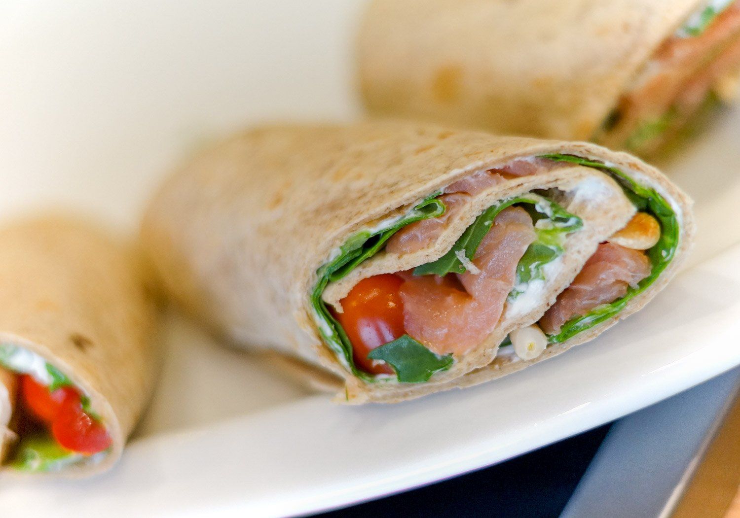 Eine Nahaufnahme eines Tortilla-Wraps auf einem weißen Teller.