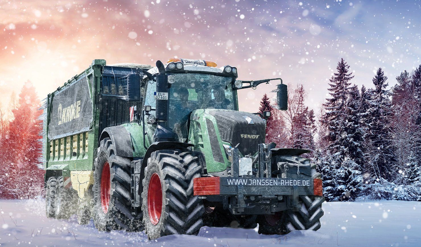 Ein Traktor mit Anhänger fährt durch den Schnee.