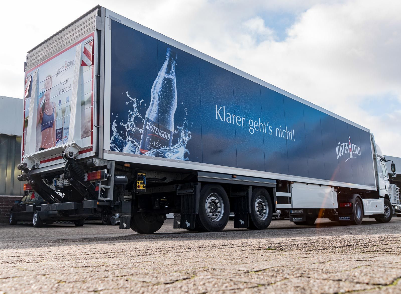 Ein blau-weißer Sattelschlepper steht am Straßenrand.