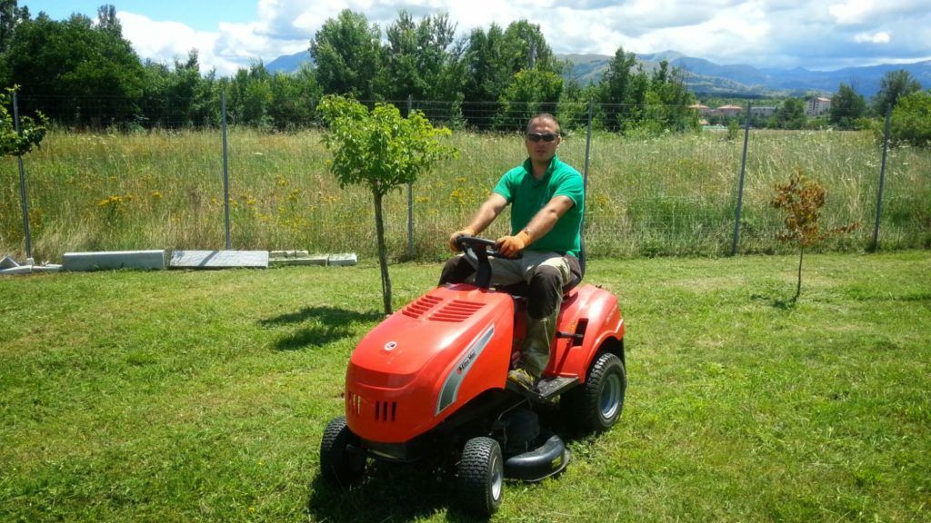 Un uomo sopra ad un tagliaerba
