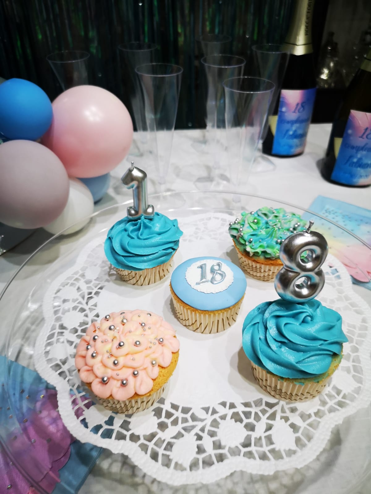 Cupcake con glassa e candeline. Festeggiamo il nostro diciottesimo compleanno con palloncini e bicchieri.