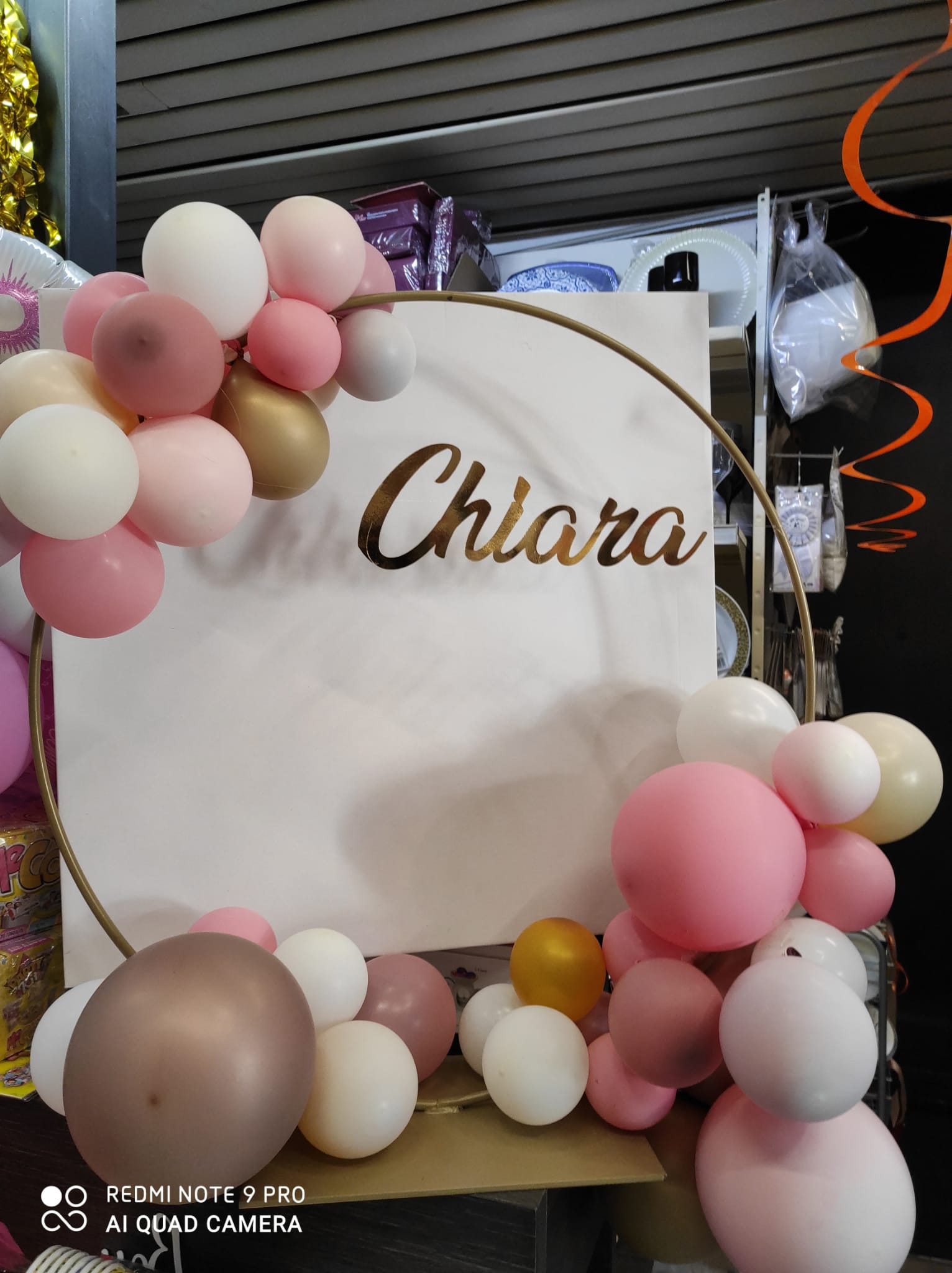 Targa con il nome Chiara con palloncini rosa, bianchi e dorati su un quadrato bianco e una cornice dorata.