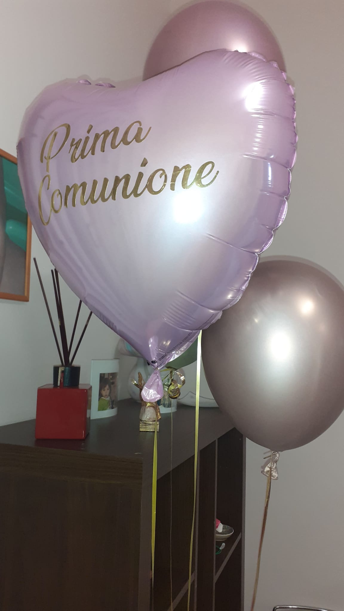 Tre palloncini, uno a forma di cuore con la scritta
