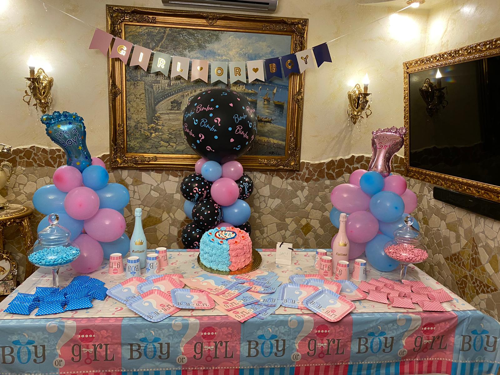 Festa per rivelare il sesso del nascituro con decorazioni rosa e blu, palloncini, torta e striscioni.