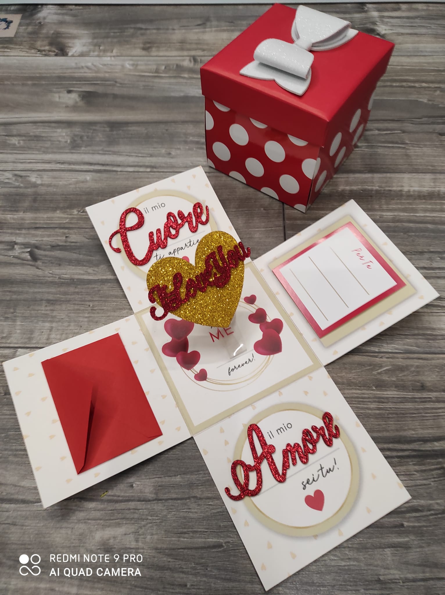 Scatola esplosiva con coperchio a pois rossi e decorazioni a forma di cuore con la scritta