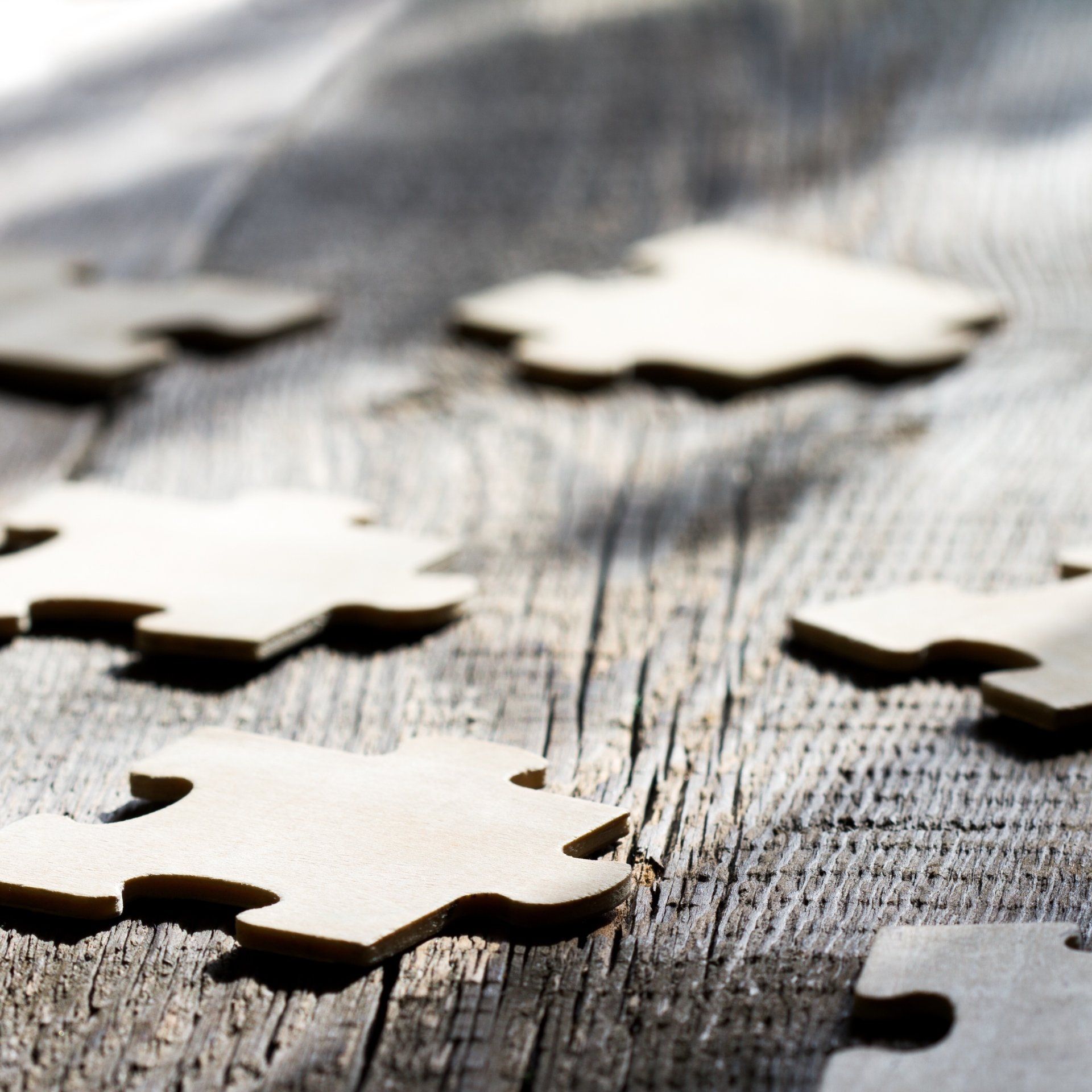 A bunch of wooden puzzle pieces on a wooden table