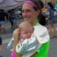 Mother smiling and holding a sleeping baby