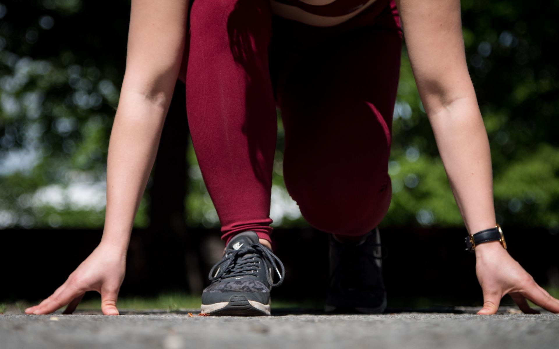 Legs, feet, and hands of person ready to start running race