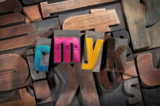 The word cmyk is written in wooden letterpress type