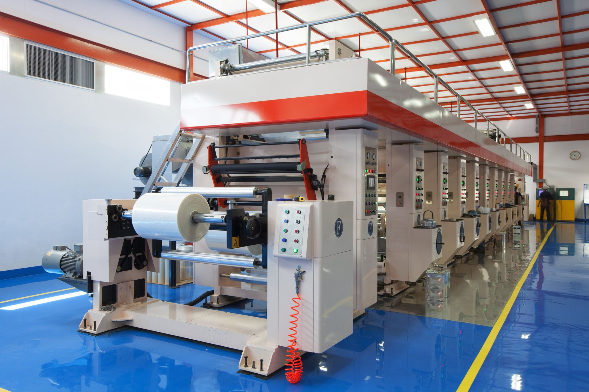 A large machine is sitting in a factory with a blue floor.