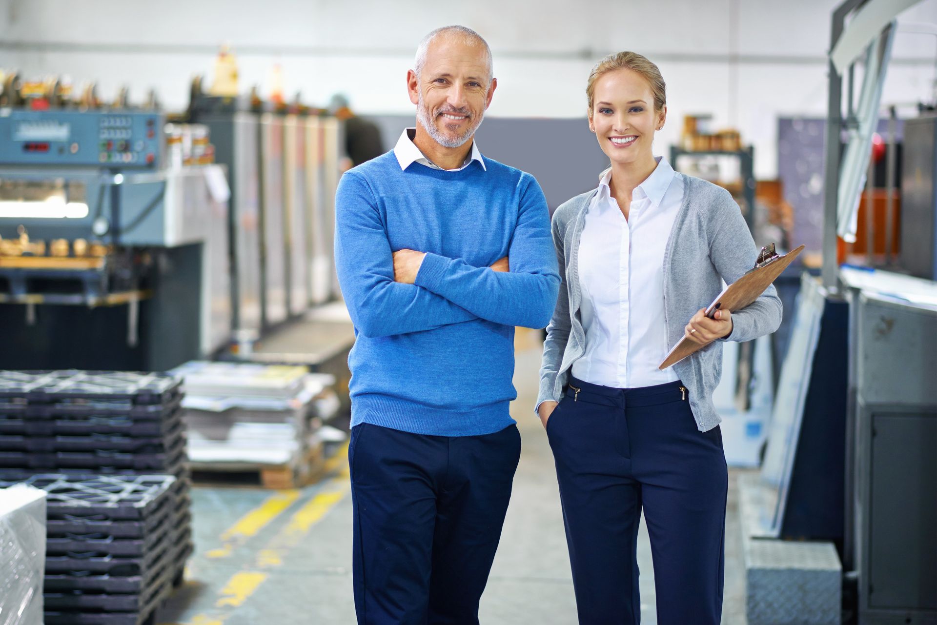 A man and a woman are standing next to each other in a factory.