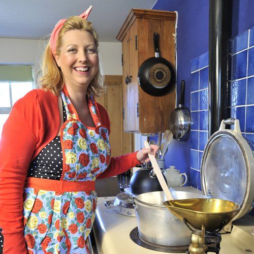 A woman in 1950s clothing cooking