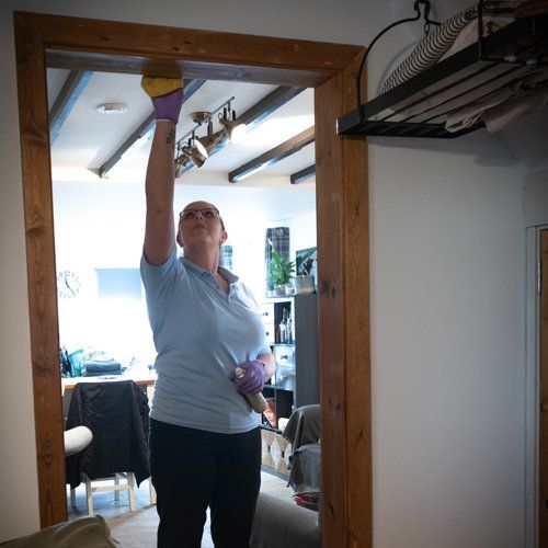 A woman cleaning a large mirror