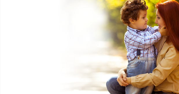 A woman is holding a little boy in her arms.