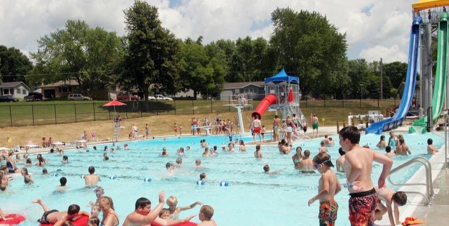 A group of people are swimming in a large swimming pool.
