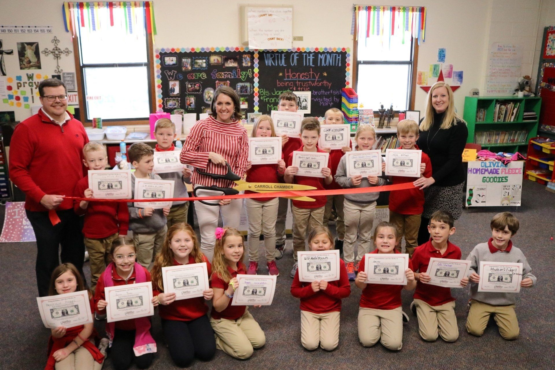 A group of children are holding up signs in a classroom.