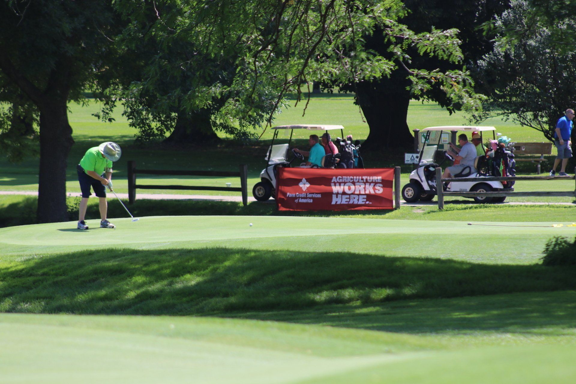 A man is putting a golf ball on a golf course.