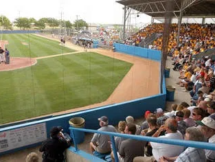 A crowd of people are watching a baseball game in a stadium.