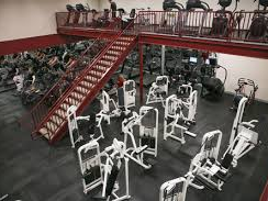 A large gym filled with lots of exercise equipment and stairs.