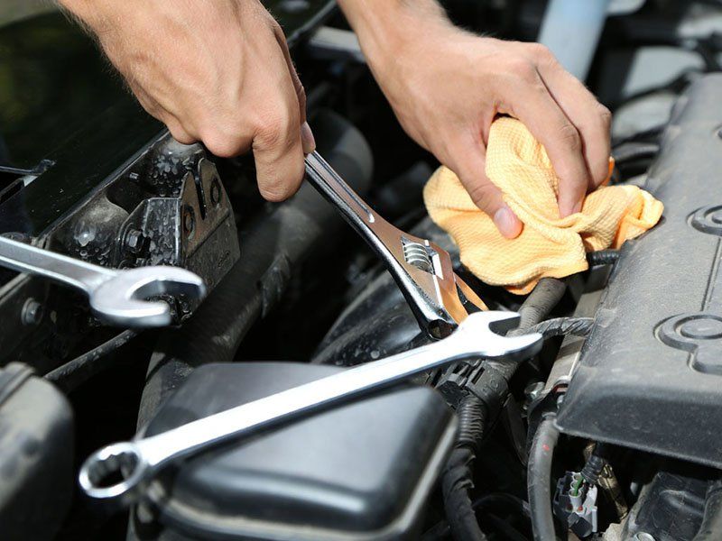 operatore impegnato in una riparazione meccanica di un auto