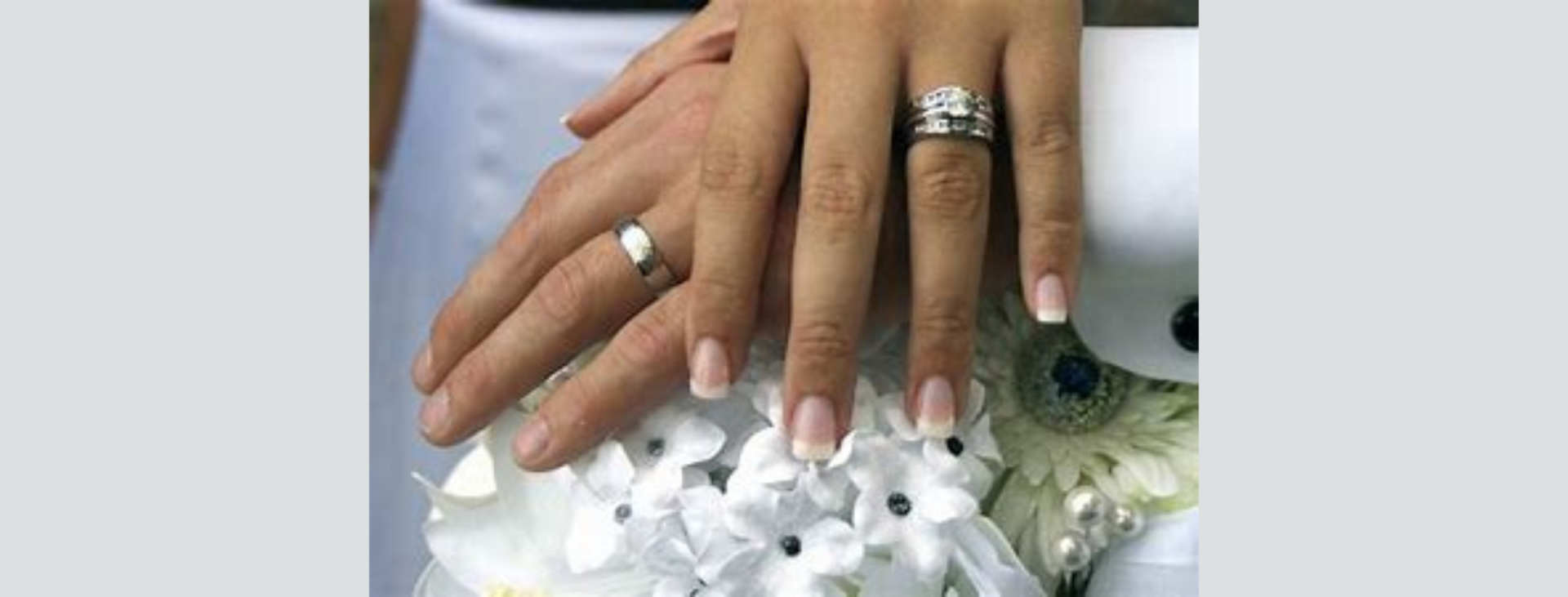 silver wedding bands on man and woman's hands
