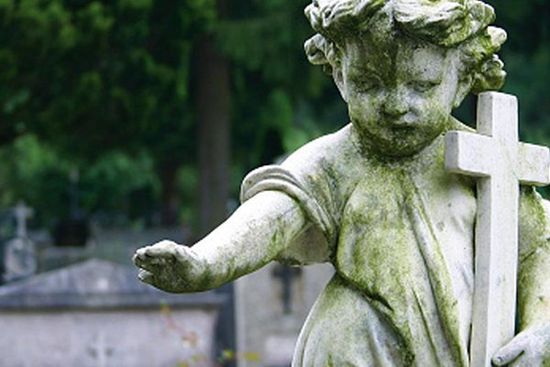 una statua di un angelo con una croce in mano