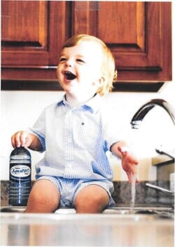 Child holding a bottle of water — Water Filters in Magnolia, NC