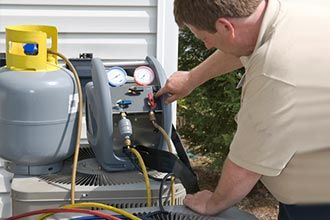 Technician repairing air conditioner - HVAC Services in Kernersville, NC
