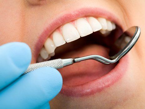 Teeth Whitening — Dentist Checking the Teeth Using Dental Mirror in Brownsburg, IN Teeth Whitening — Dentist Checking the Teeth Using Dental Mirror in Brownsburg, IN