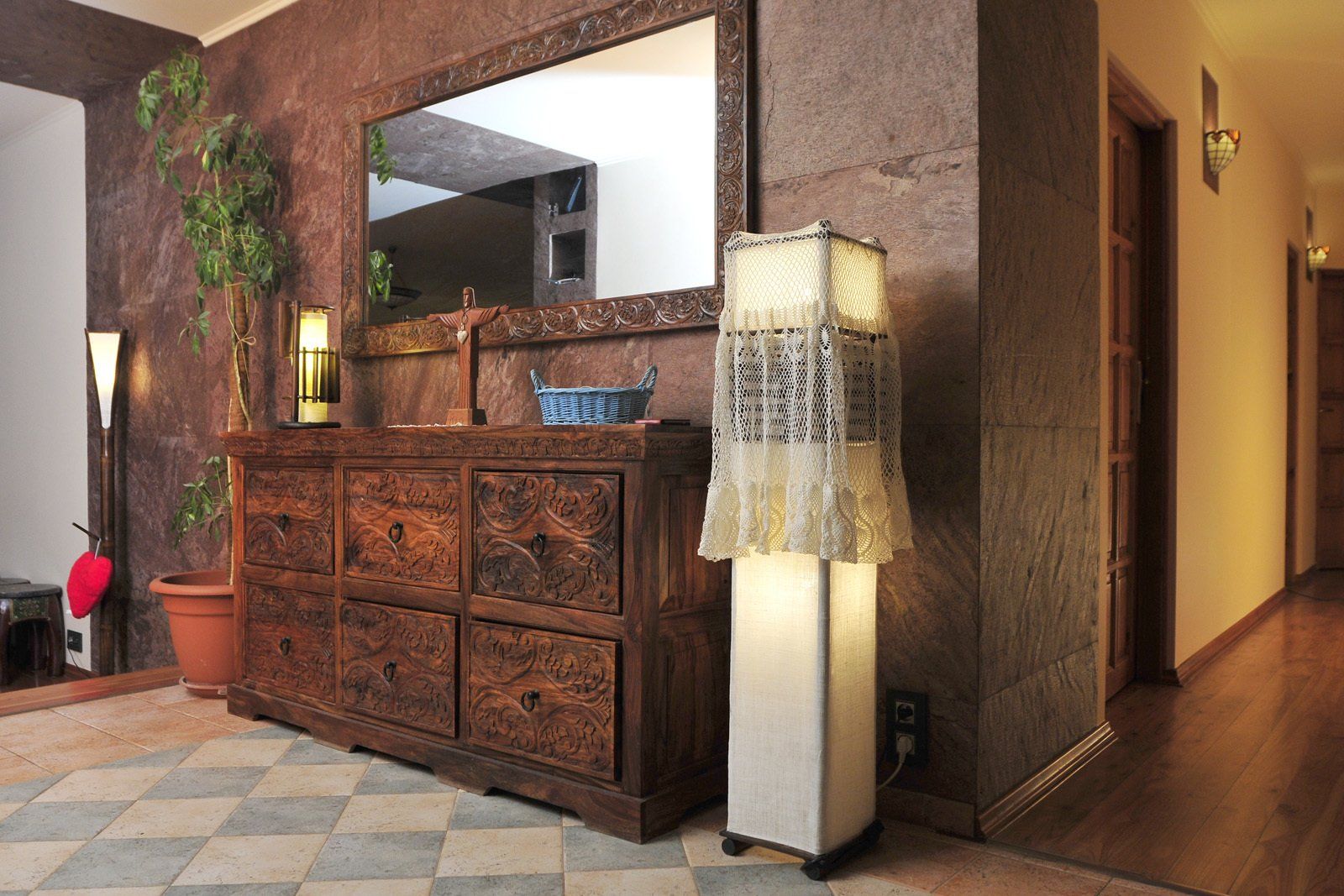 Entryway with wooden cabinet, large mirror, and patterned floor. A tall lamp stands to the right.