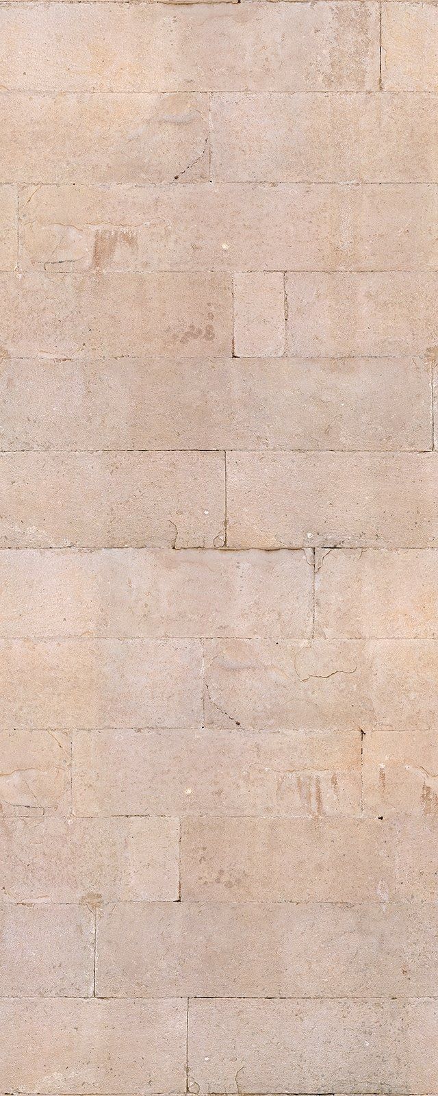 Close-up of a wall made of light beige rectangular stone bricks.