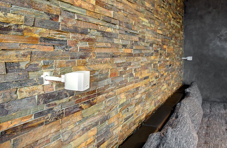 Stone brick wall with two white electrical outlets.