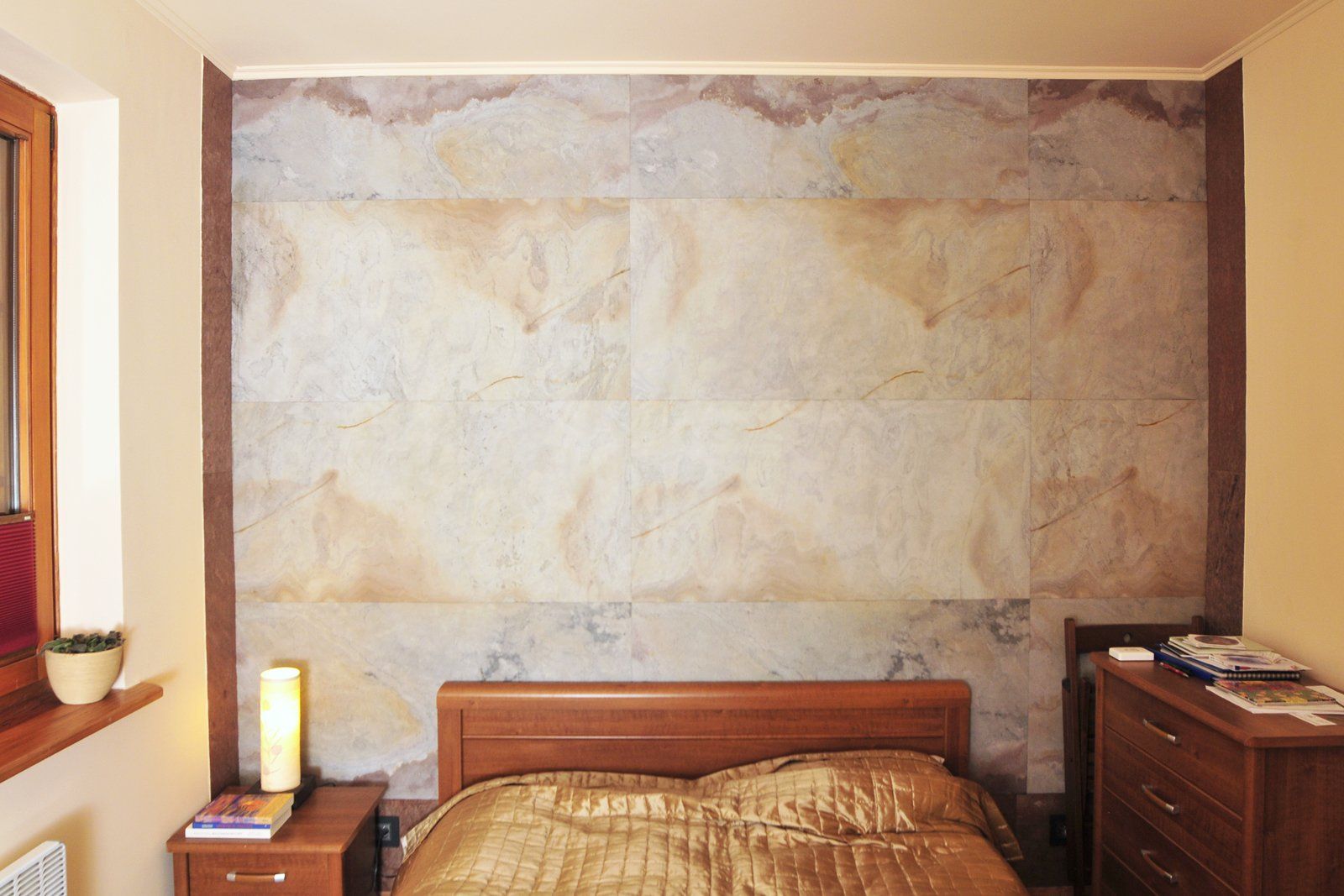 Bedroom with textured wall behind a wooden bed, nightstand, and dresser.