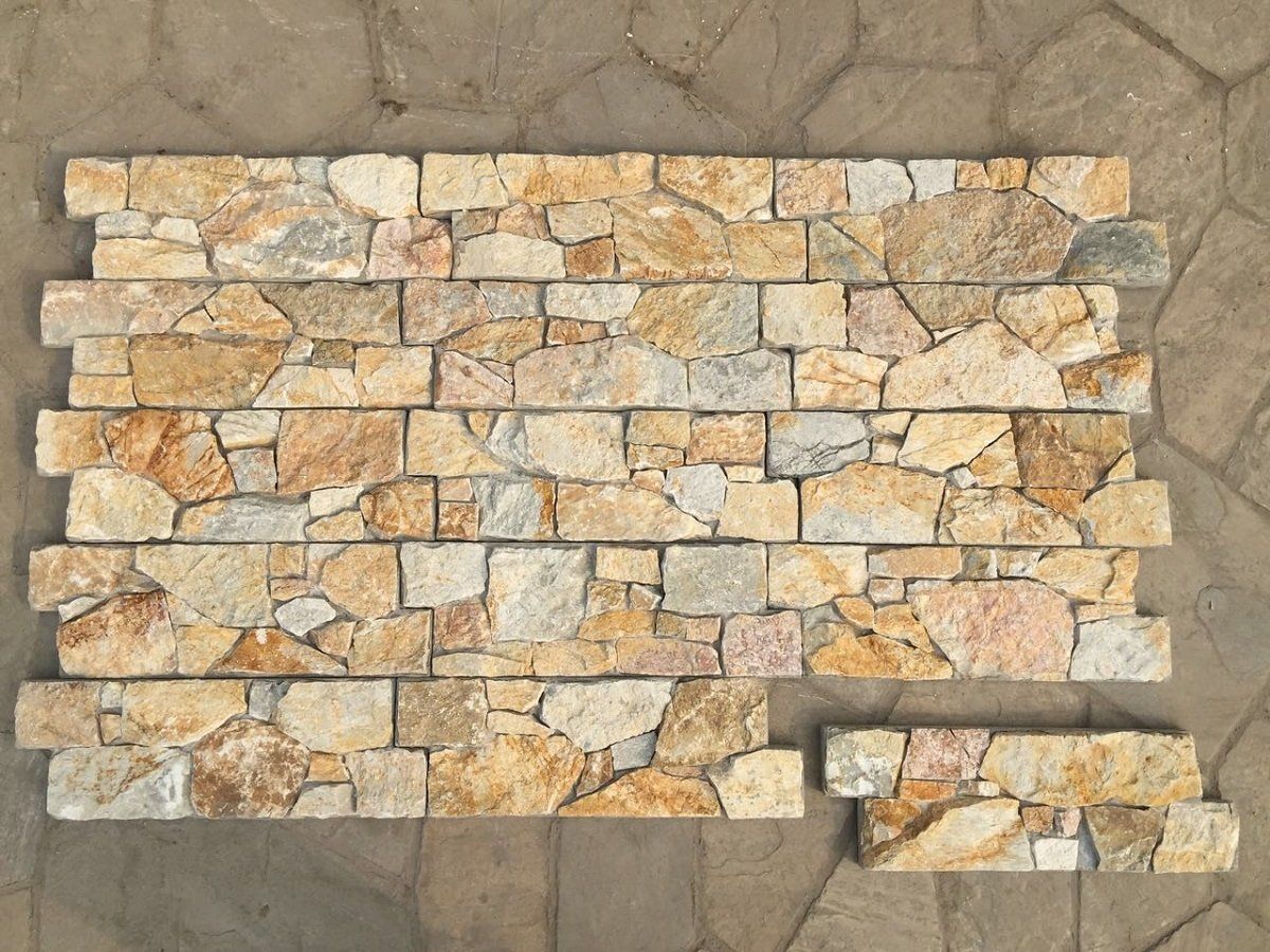 Stone tile wall with varying shades of tan, beige, and gray.