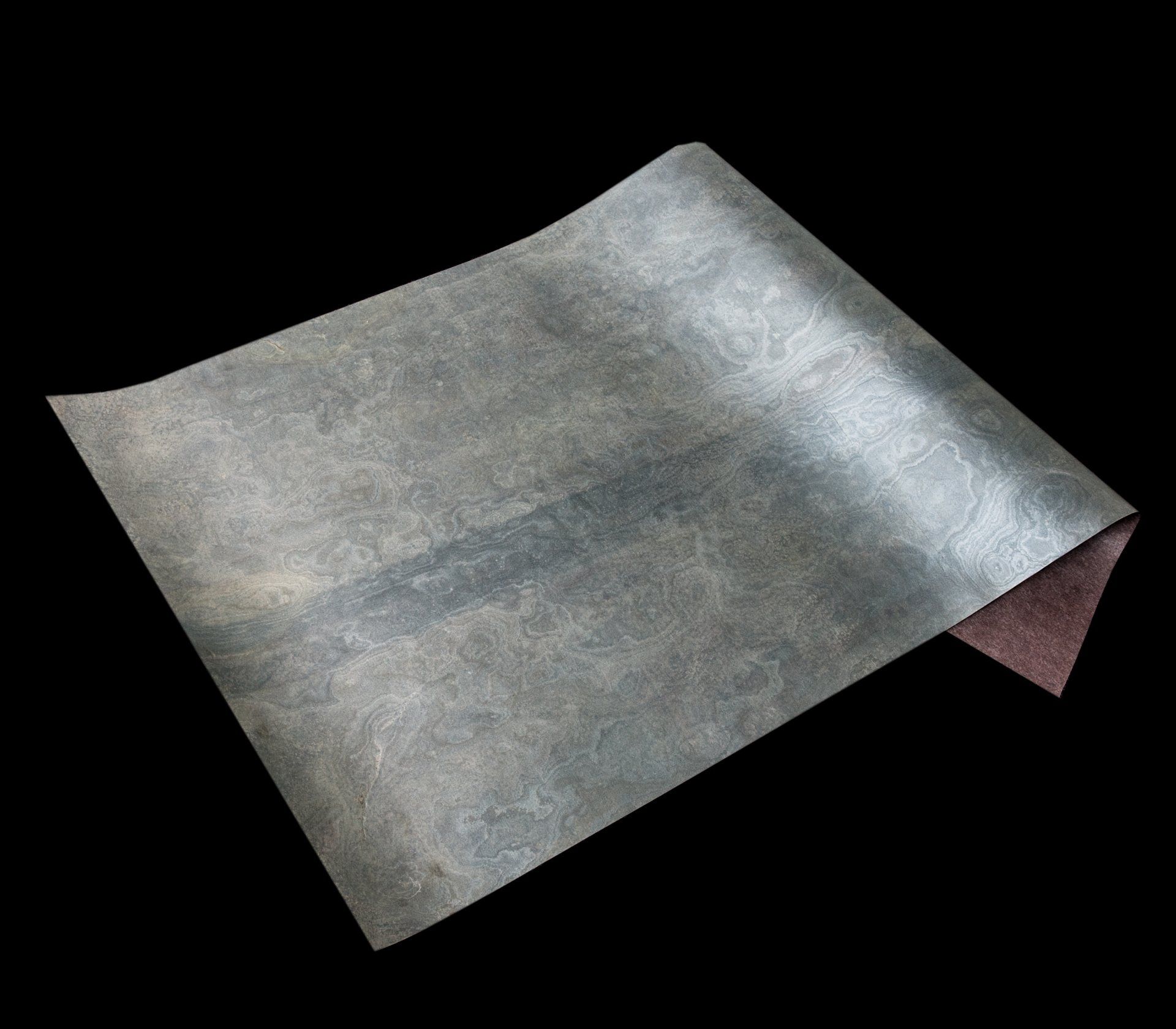 Gray textured paper sheet, curled, on black background.