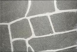 Gray stone pavers with white grout lines.