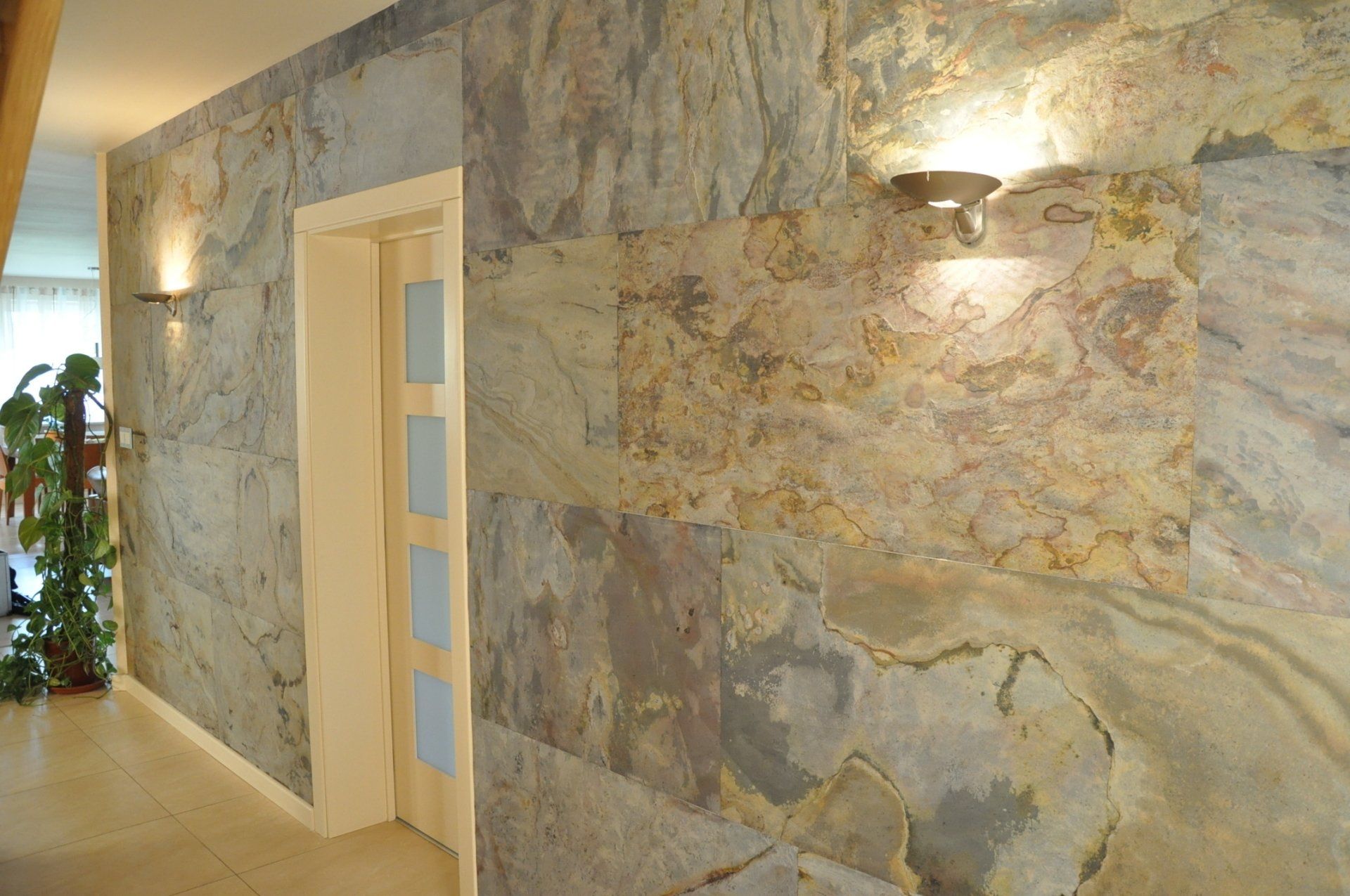 Hallway with stone wall and two sconce lights. Doorway.