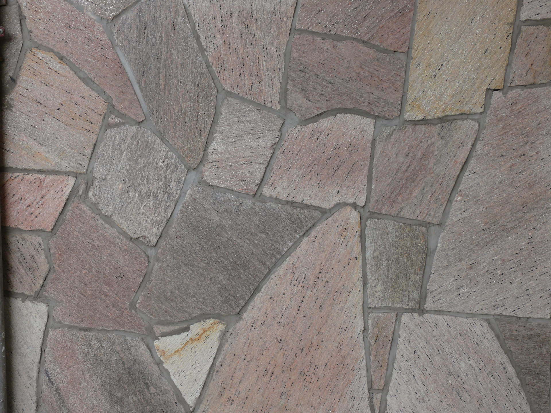 Stone wall, irregularly shaped tiles in shades of brown, gray, and beige.