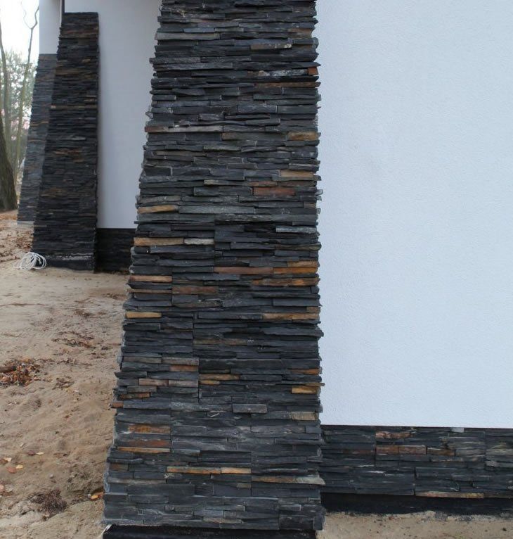 Stone veneer accenting a white building column, featuring dark gray and tan stacked stone.