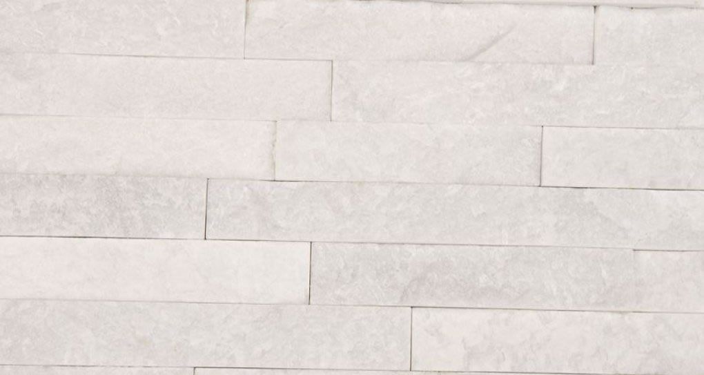White stone wall cladding with rectangular, textured pieces.