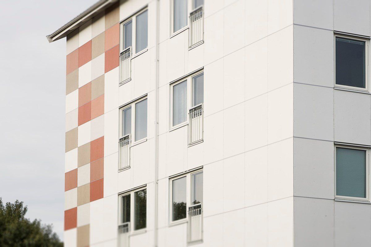 Multi-story white building with red and orange checkered accents on the side.