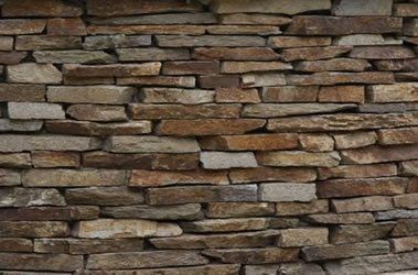 Stone brick wall with tan, brown, and gray rectangular stones arranged horizontally.