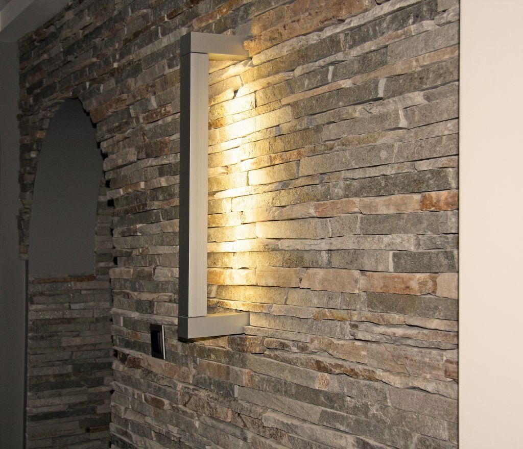 Stone wall with inset light fixture; alcove to the left.