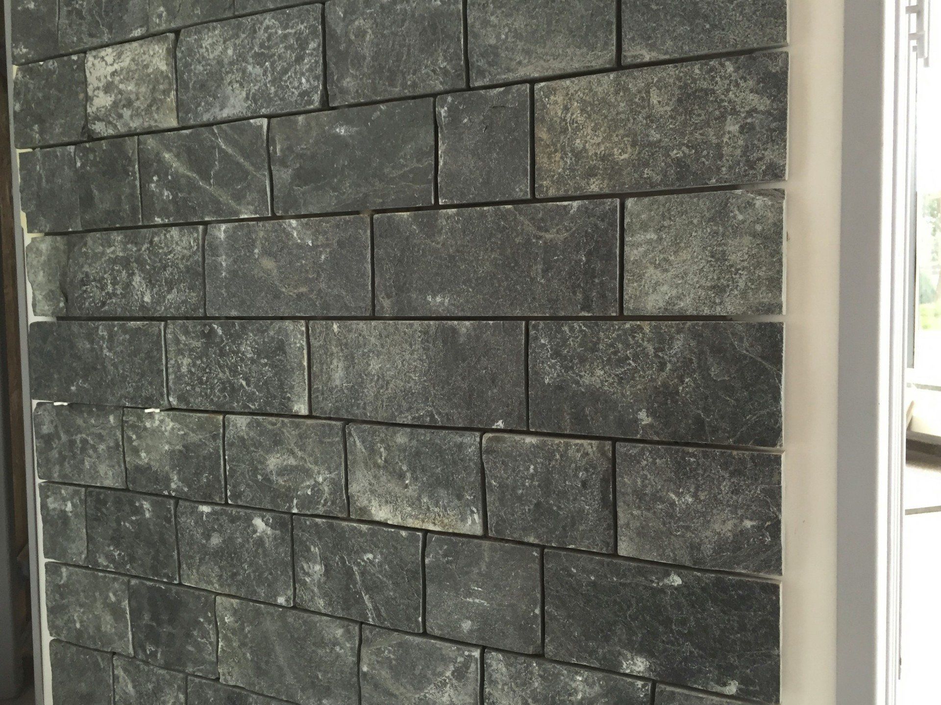 Stone brick wall, dark gray with varying textures.